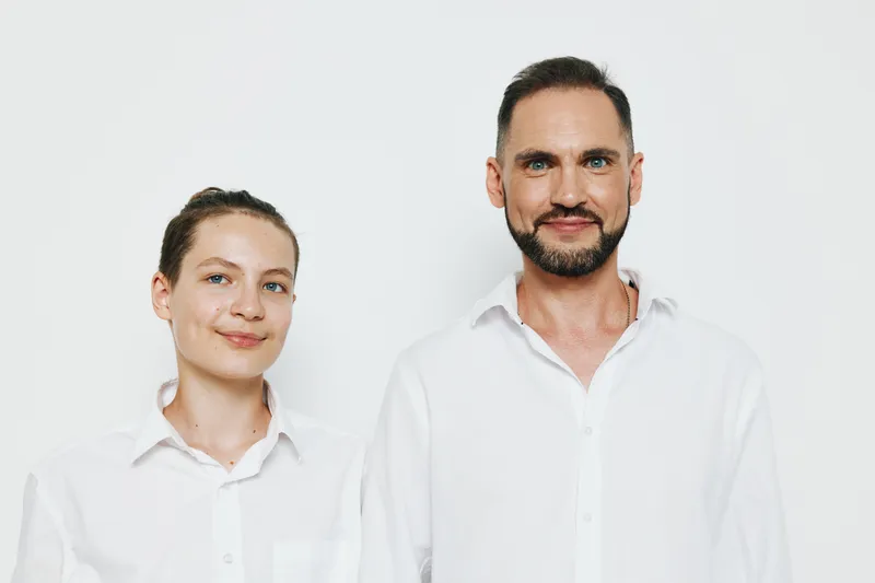 A professional man and colleague stand on a clean white background, projecting confidence and calm for corporate, business, and success themed visuals suitable for modern workplaces.