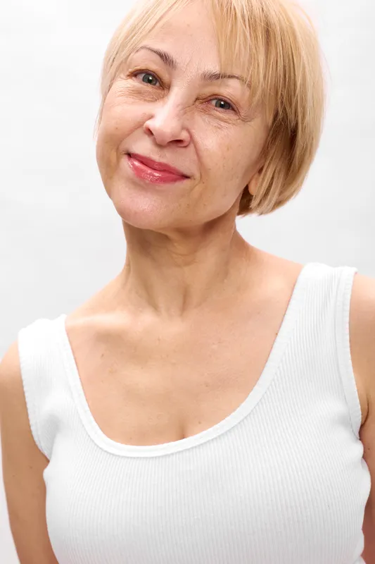 Elderly woman portrait, smiling senior closeup on white background, female mature headshot, relaxed expression, soft studio light, calm mood