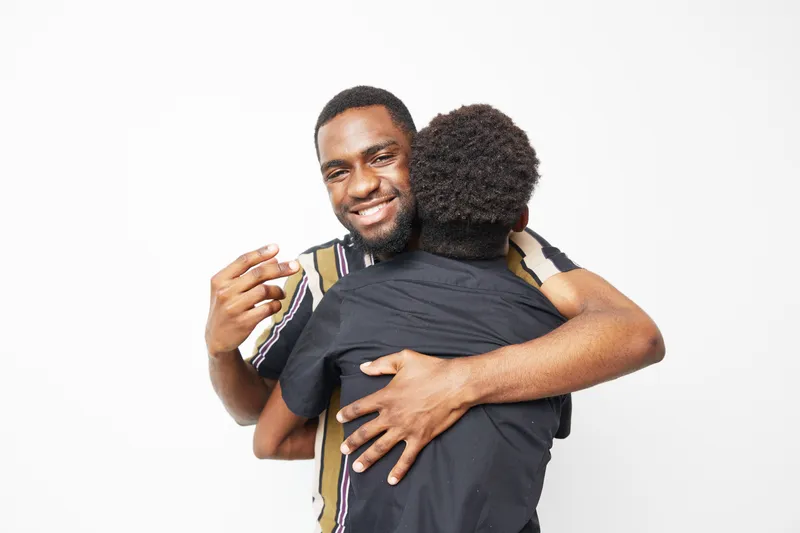 Happy African American man embracing a child, showcasing a strong bond of love and joy. Their warm smiles bring a sense of connection and happiness.