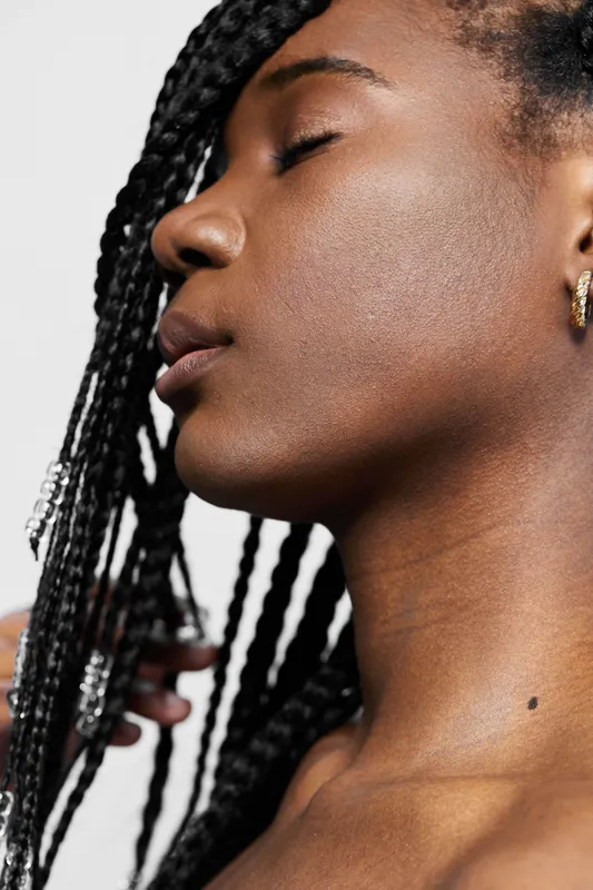Portrait of a serene young woman with braided hair, showcasing beauty and confidence against a minimalistic background Emphasizes self expression and empowerment