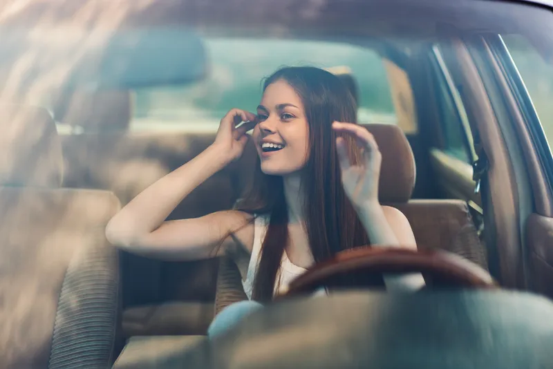 Joyful girl enjoying a road trip in a car, smiling and having fun while driving. Capture of happiness and adventure, perfect for travel concepts.