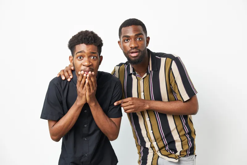 Two surprised African American men showing excitement and astonishment. Their unique expressions capture a moment of unexpected joy and fun together.