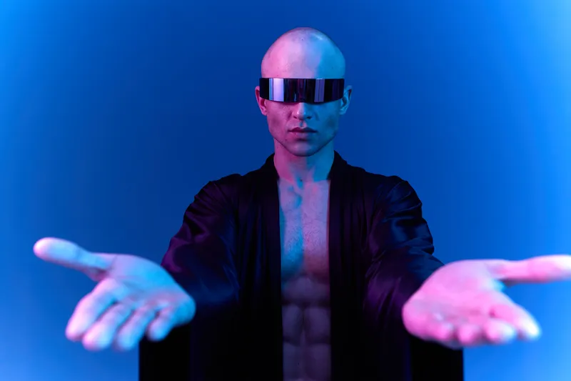 Futuristic man posing confidently with outstretched arms, showcasing modern style and vibrant blue lighting, ideal for technology and innovation themes.