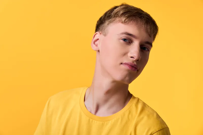 Young man, yellow background, monochrome, casual, fashion, lifestyle, model, upbeat, clean composition for advertising, fashion content, and lifestyle branding