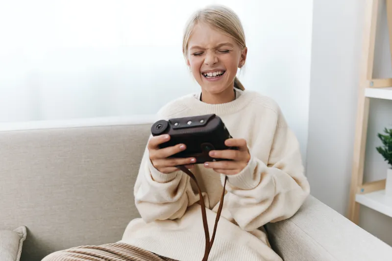 Authentic moment of a young student absorbed in gaming at home, showcasing focus, joy, and a relaxed school lifestyle in a cozy setting that blends play and study.