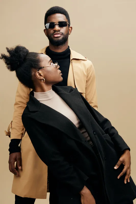Stylish young couple in trendy outfits, exuding confidence and modernity against a neutral background in a contemporary fashion setting