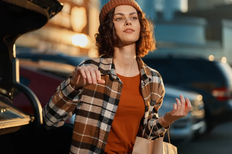 Woman shopping portrait on an urban street at golden hour, candid lifestyle scene with authenticity, golden hour glow, mindful living and emotional storytelling in warm autumn tones.