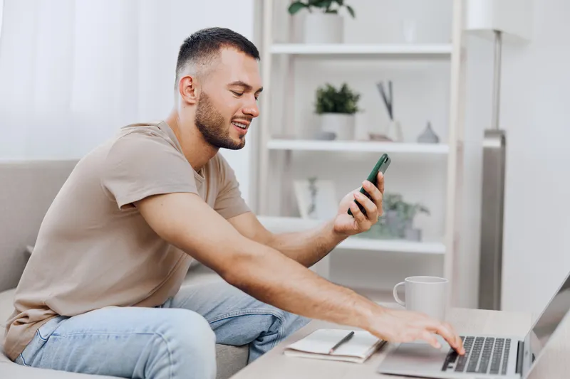 Calm man engaging in digital detox while working from home, blending personal life with professional tasks. Embracing soft masculinity and emotional minimalism.