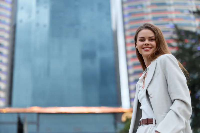 confident woman in beige suit smiling outdoors with urban business background, professional woman, fashion, business, modern woman, smiling woman