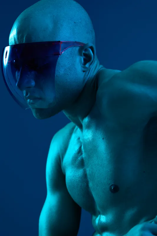 Man with sunglasses in a futuristic style, highlighted by blue lighting. This black and white image captures a powerful and striking representation of strength and determination.