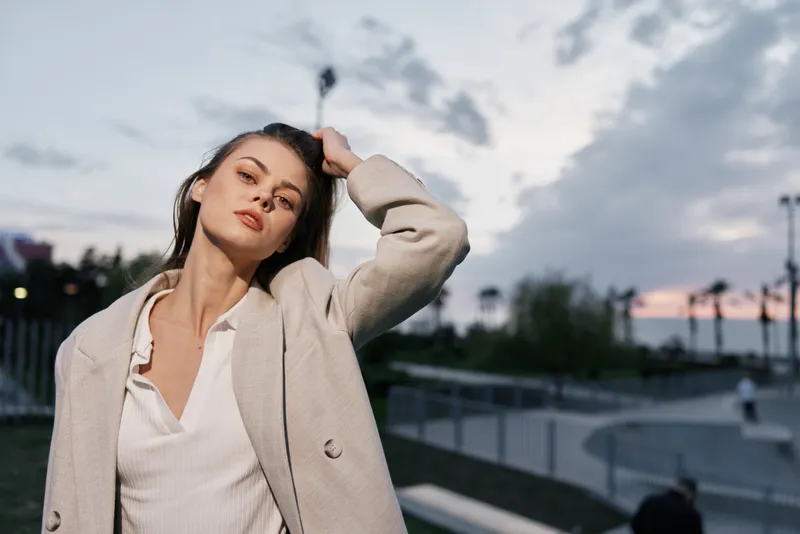 Confident businesswoman in a stylish outfit exuding professionalism against a sunset backdrop, embodying modern empowerment and elegance.