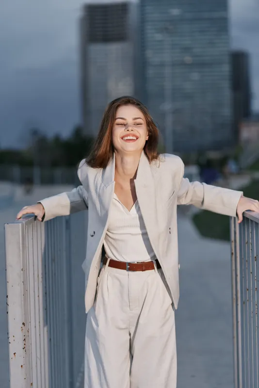 confident woman in white business suit smiling outdoors urban background business confidence success casual fashion