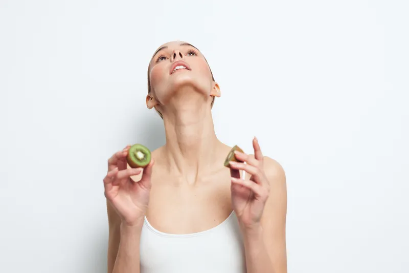 Woman skincare beauty wellness spa facial self care cucumber green relaxation concept, calm portrait of a woman holding cucumber slices near her face, minimal studio white background for hydration