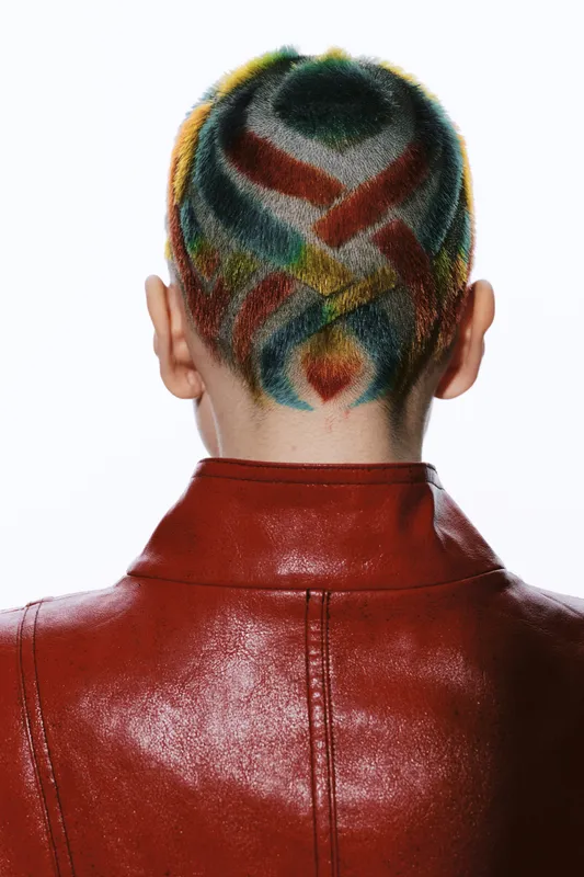 woman with colorful shaved hairstyle wearing a red leather jacket, creative fashion and unique hair design on white background, modern and bold look