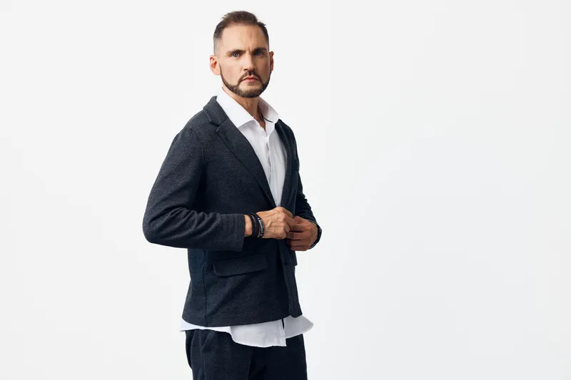 A professional business man in a tailored suit stands confidently, expressing focus and determination against an isolated colored background, ideal for leadership, corporate branding and media.