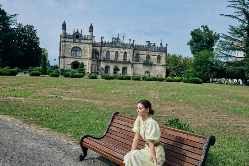woman on bench by mansion real diverse