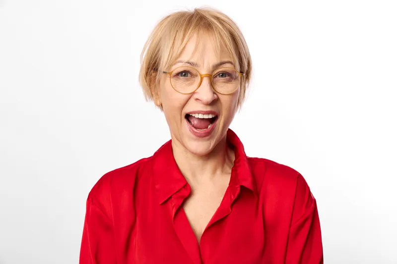 Woman blond glasses red studio portrait excited shouting expression mouth, red shirt, short hair, open mouth, white background, clean bright even light