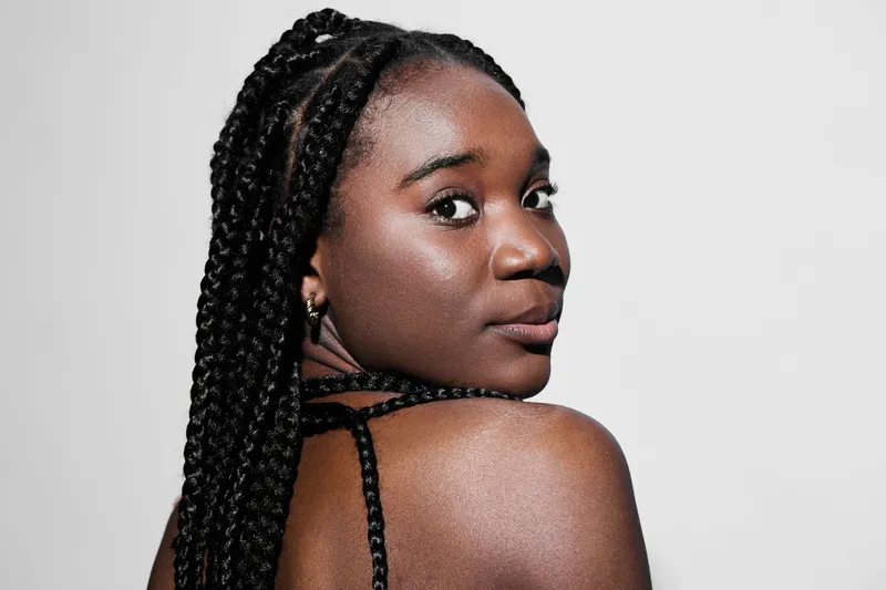 Portrait of a confident Black woman with braided hair, showcasing beauty and elegance against a clean white background, perfect for empowerment and diversity concepts