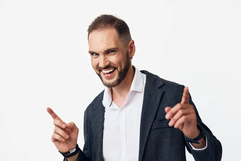 A poised business professional man stands against an isolated colorful background, radiating energy and focus, portraying leadership, confidence, and momentum.