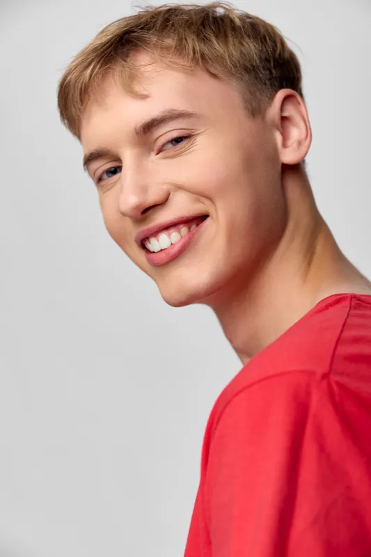 Smile, young man, red shirt, casual style, happy expression, positive energy, clean backdrop, fashion and lifestyle focus, approachable and cheerful mood for stock photography