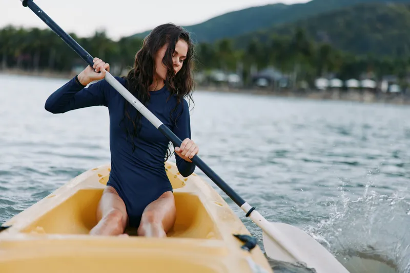 young woman kayaking on calm water with paddle adventure, nature, sport, outdoor activity, summer, water