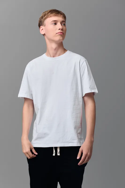 young man, white tee, casual style, neutral background, fashion, minimalist, everyday wardrobe, basics, lifestyle, studio, model, clothing, outfit, relaxed pose, monochrome, clean look, slim fit,