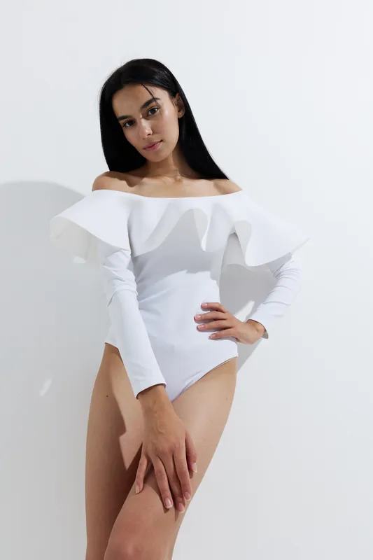 woman sport fitness wearing white off-shoulder outfit posing against bright white background, showcasing strength and grace with focused expression and natural look