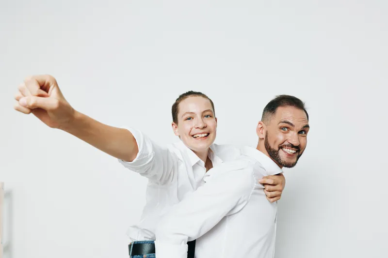 Professional man in a business scene with a colleague, displaying strong emotions and confidence. An isolated colored background enhances the celebratory mood as they share a joyful moment of