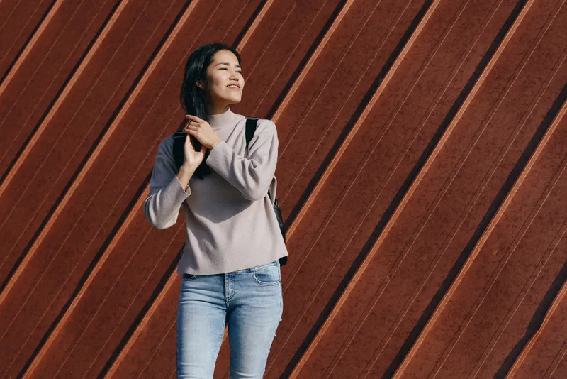 Backpack, woman, casual, fashion, outdoor, urban, style, confidence, journey, youth, standing beside a warm wooden wall, showcasing modern streetwear and relaxed everyday mobility