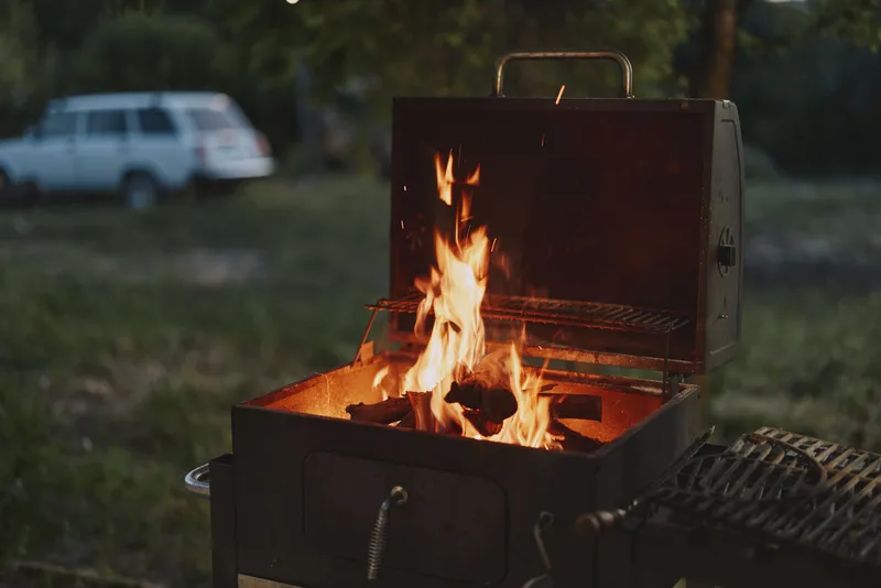 Grilling with Flames in a Backyard Barbecue Setting During Summer Evening