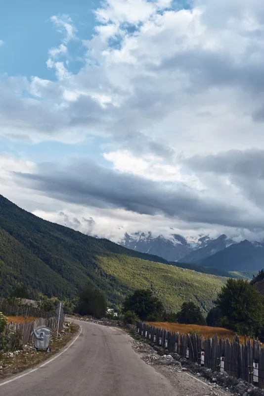 Mountain road, clouds, landscape, village, fence, trees, sky, hills and green nature with winding path through rural valley and peaks