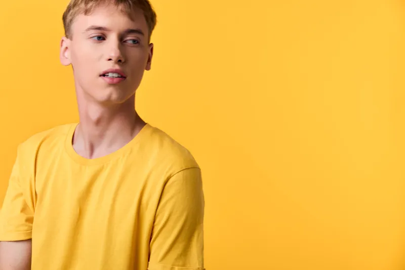 Casual fashion shot of a man in a yellow shirt against a bright yellow studio backdrop, clean lighting and minimalist composition for lifestyle and apparel use