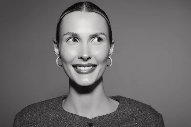 Smiling white caucasian woman with light skin and pulled back hair looks away in black and white photo. Concept of happiness and female portrait.