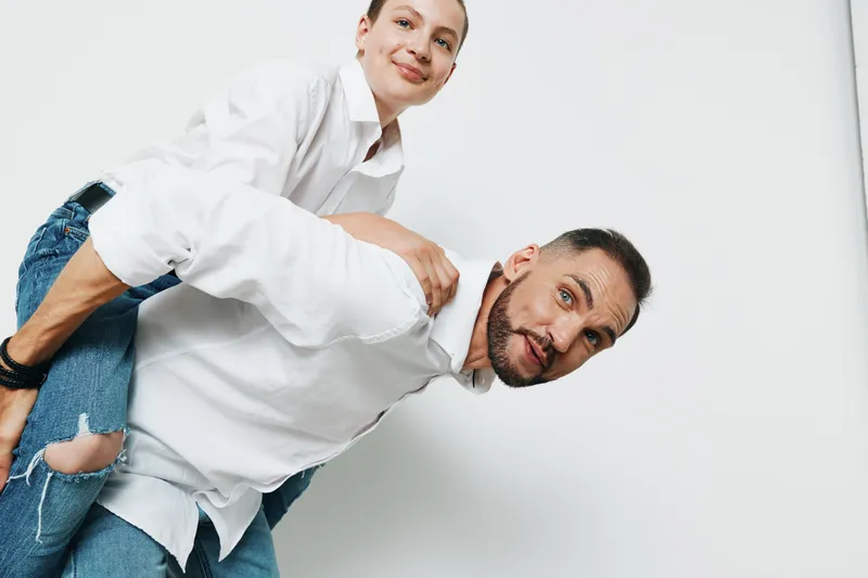 Professional businessman and colleague with a playful pose against an isolated colored background, conveying confidence, joy, and teamwork through positive emotion and dynamic teamwork.