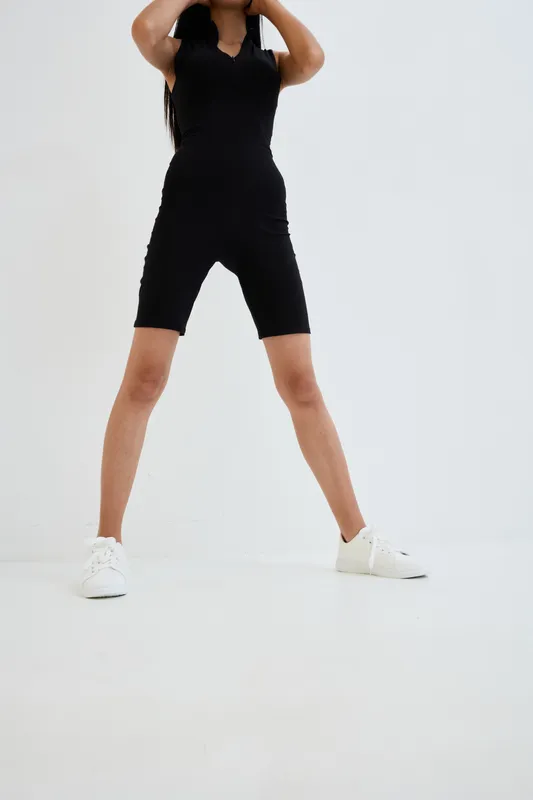 woman posing in black romper and white sneakers with long hair, isolated on white background, casual style, full-length view, minimalistic fashion photography