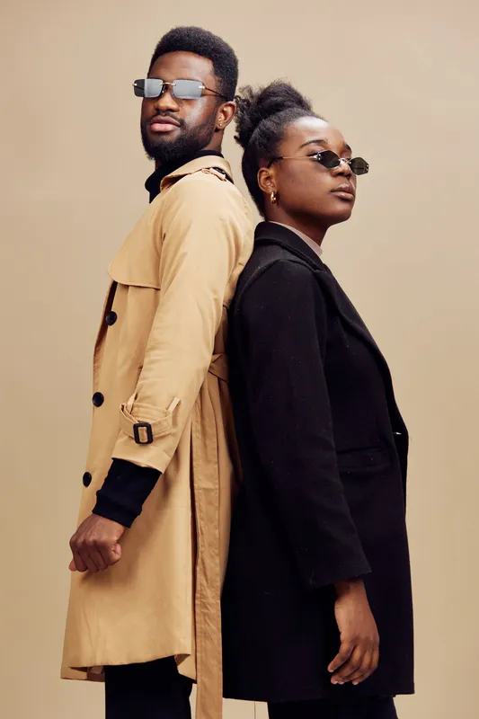 Fashionable young couple in stylish outfits, expressing confidence and individuality against a neutral background Emphasizing modern urban style and contemporary relationships