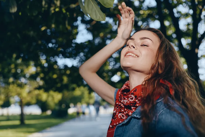 Lifestyle woman enjoying sunny day in modern boho-western denim street style with vibrant film color and relaxed positive mood outdoors