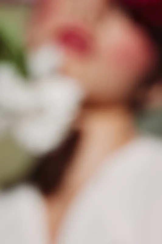 Abstract creative beauty portrait with soft focus. Model poses gently with white flower. Concept for fashion editorial, artistic expression, and modern elegance.
