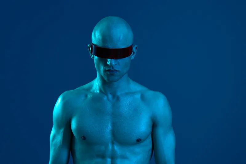 Striking man with futuristic sunglasses, showcasing a unique blue glow against a dark background. The image captures a bold, modern aesthetic, perfect for technology themes.