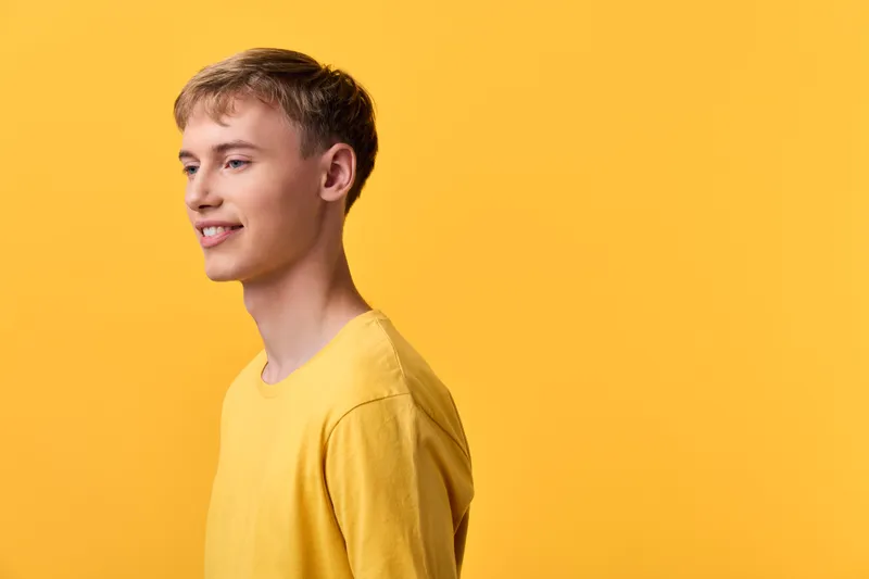 Man profile yellow background casual outfit smile youth brightness color fashion studio shot male sunshine cheerful pose simple minimal clean vibrant warm emotion relaxed contemporary everyday space