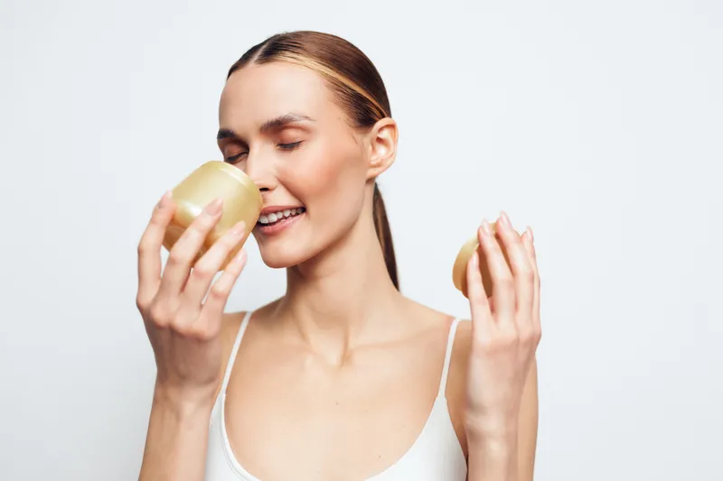 Young woman drinking water from glass, relaxed smile, clean white background, refreshing hydration concept, wellness and healthy lifestyle, skincare routine, copy space