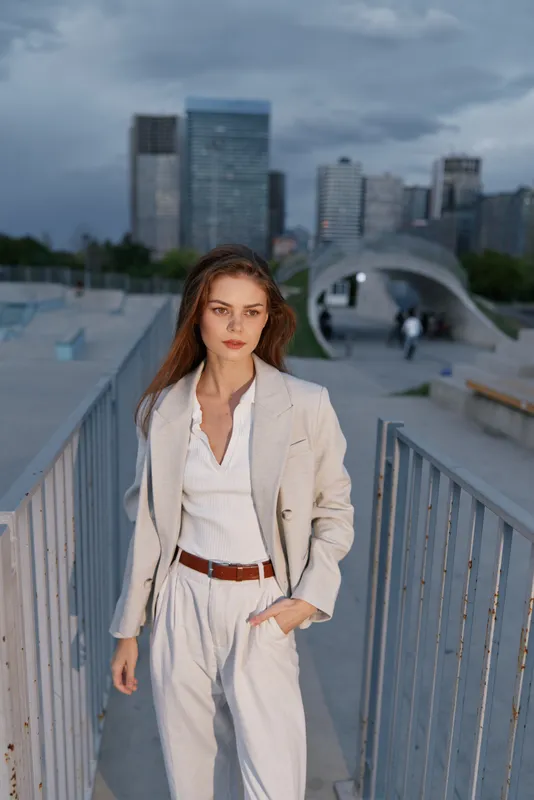 confident woman in light business suit walking urban cityscape with modern buildings cloudy sky financial crisis concept