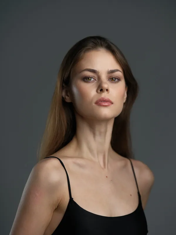 serious woman with long hair wearing black top on neutral background, portrait, fashion, beauty