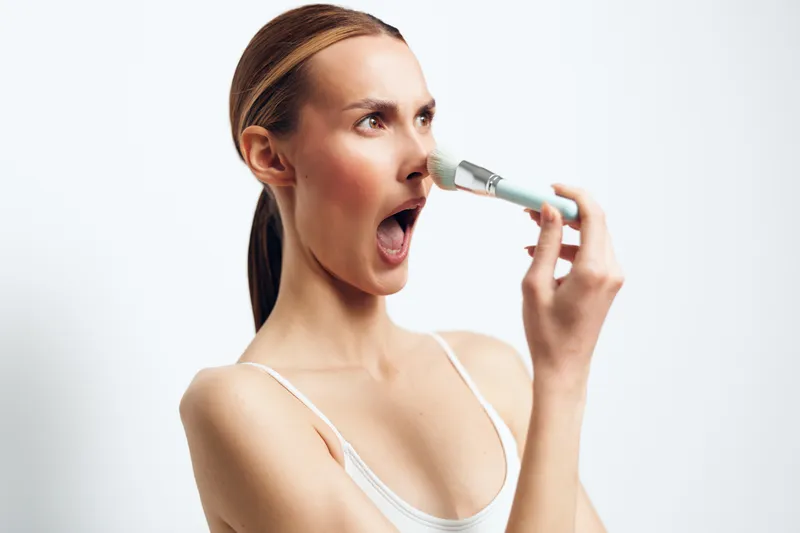 Young woman with inhaler spray, mouth open as she breathe mist, respiratory medicine for asthma, healthcare health concept, treatment, clean white studio, copy space