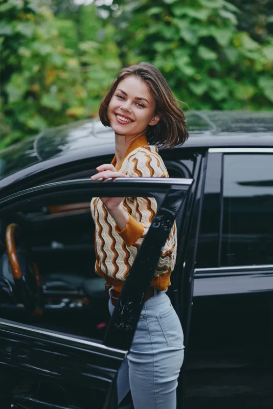 Car, woman, smile a cheerful woman stands by a sleek car with an open door, radiating joy, confidence, and readiness for a pleasant journey outdoors, fashionably dressed.