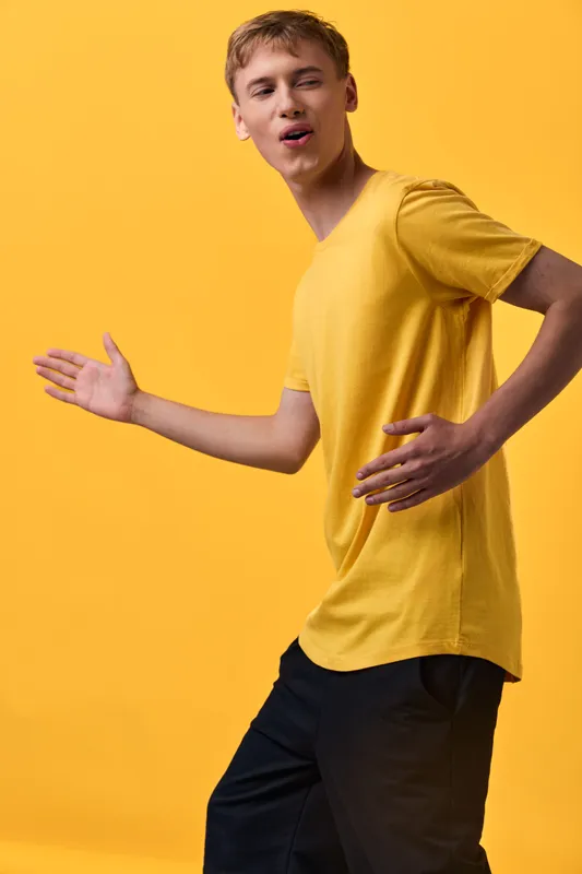 Dance, motion, yellow shirt, youth, dynamic pose for advertising, fashion, or lifestyle images, crisp lighting, vibrant color, contemporary energy, movement suitable for upbeat campaigns