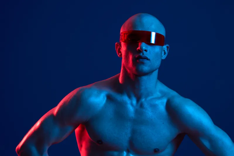 Athletic man wearing futuristic sunglasses, striking a powerful pose. The bold color contrasts create a dynamic and captivating atmosphere, emphasizing strength and style.