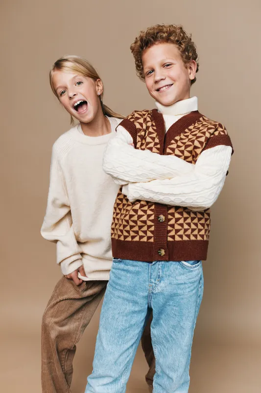 Authentic playful moment featuring children in a school lifestyle scene, showcasing friendly energy, casual attire, and genuine smiles in a candid studio portrait.