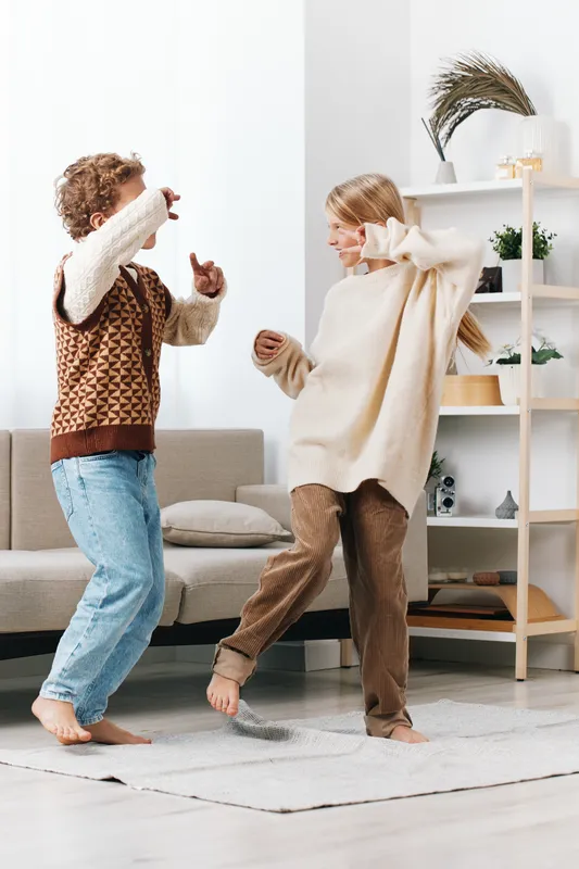 Authentic lifestyle moment showing children at play in a cozy home, capturing the theme of play and school readiness as they dance, laugh, and explore.