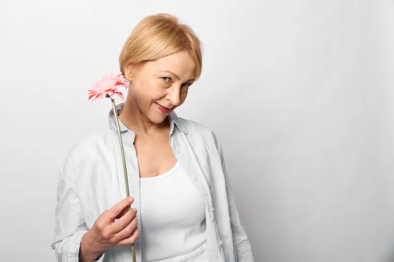 Doctor nurse healthcare stethoscope woman smile portrait medical checkup on white background, holding stethoscope, wearing white coat, warm friendly mood, studio lighting